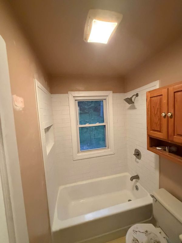 Rebuilt bathroom with white tile tub surround and new tub