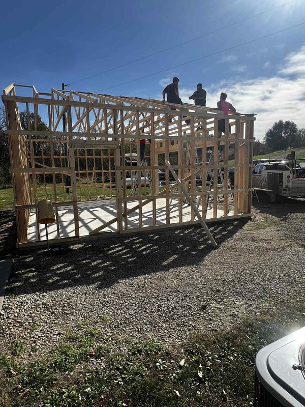 Garage or shop walls framed on a concrete slab with the crew working on the top plates